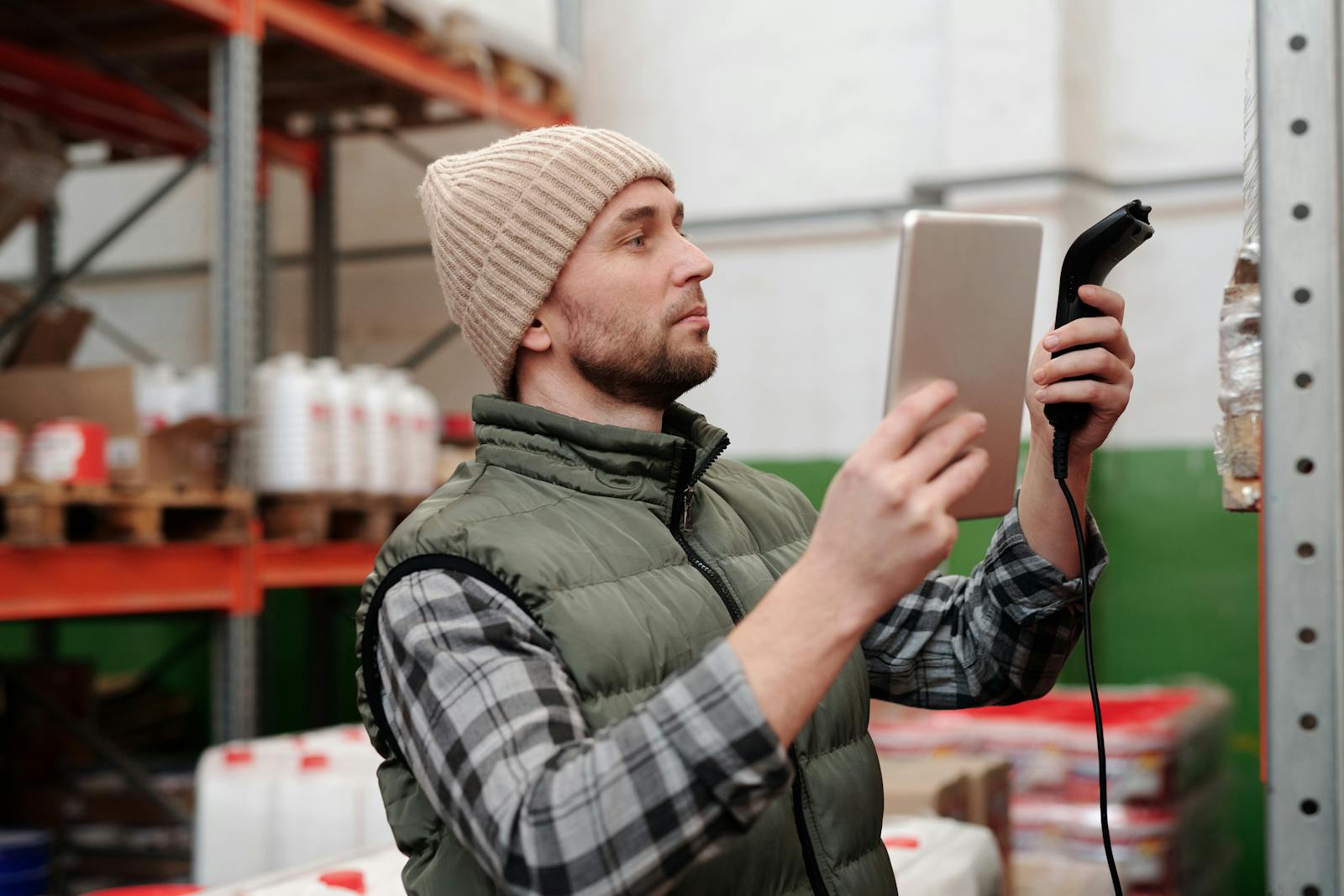 Warehouse worker scanning inventory for sourcing and delivery follow-through